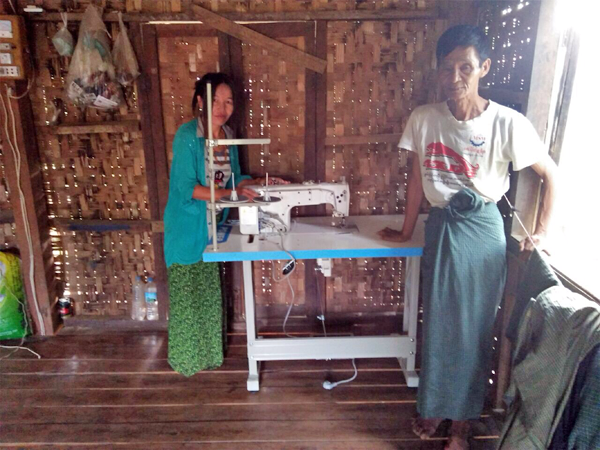 Husband And Wife Posing Near Sewing Machine